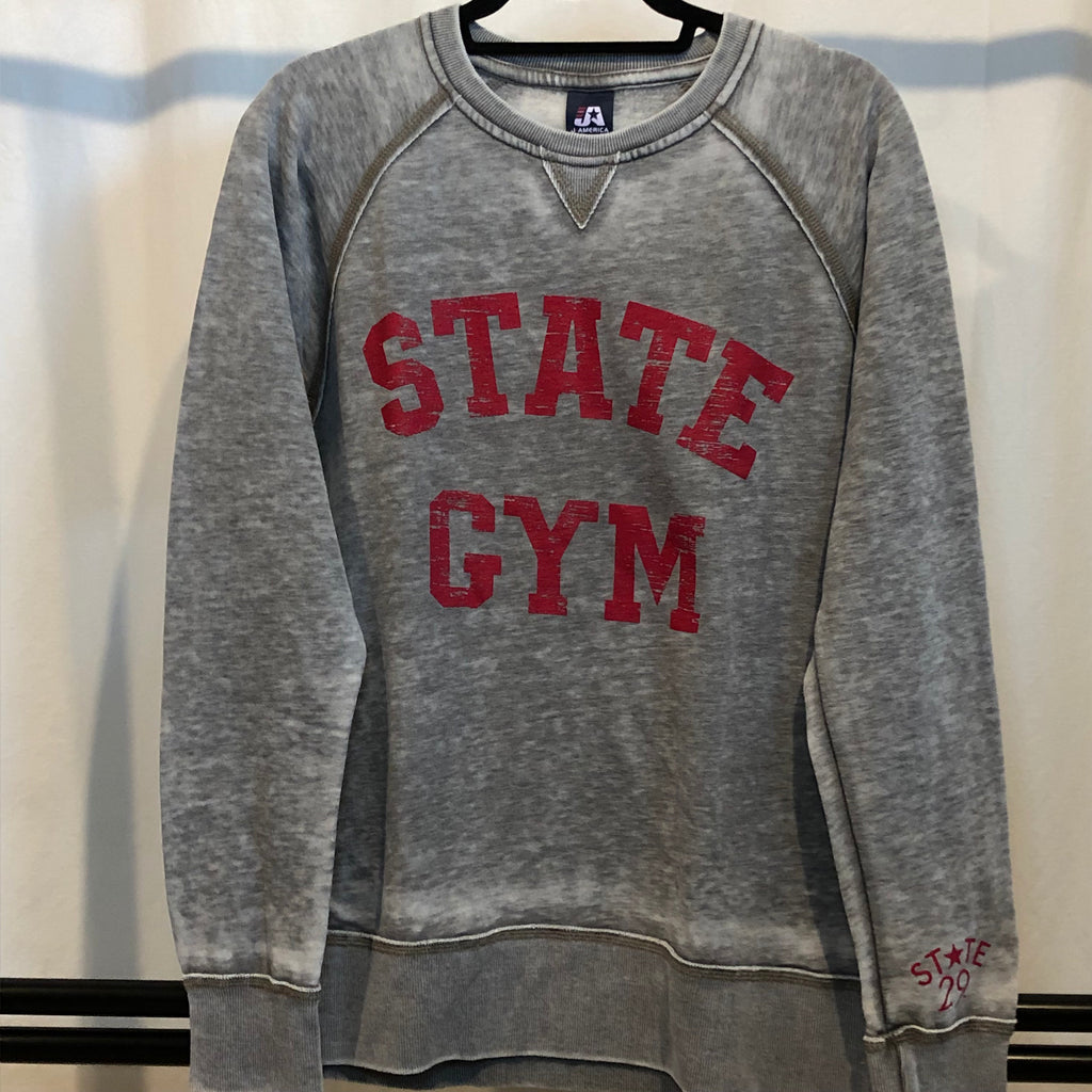 A light grey crewneck sweatshirt on a hanger with "STATE GYM" screen printed on the front in red bold all cap font