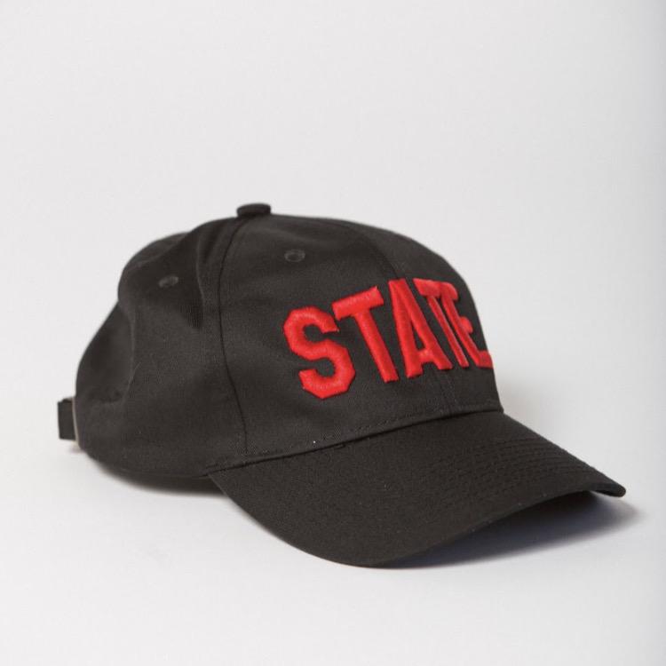 side view of black baseball hat with STATE embroidered on the front in red